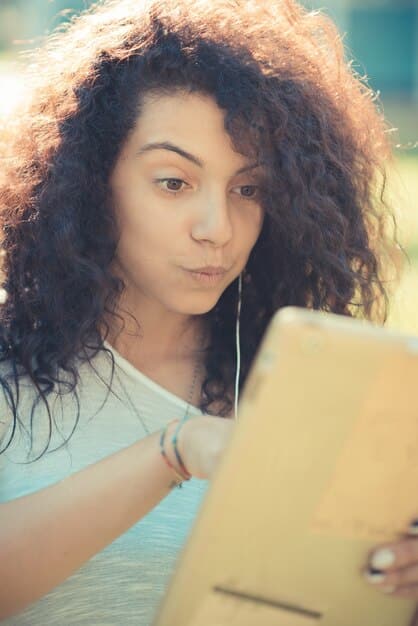 A close-up photo of a newly published novel by a Brazilian woman author, with the author's signature visible. The book is placed on a cluttered desk with notebooks, pens, and coffee cups, suggesting a writer's workspace.