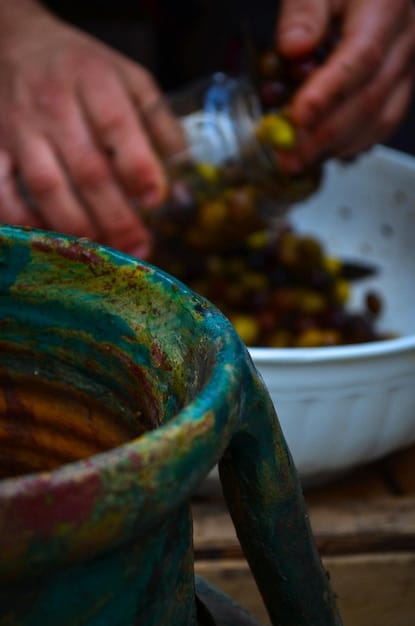 A close-up shot of an artisan using recycled materials to create a sculpture in a studio in Brazil. The image highlights the intricate details of the artwork and the resourcefulness of the artist.