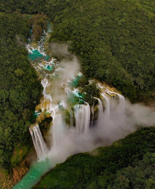 A breathtaking aerial view of the Iguazu Falls, showcasing the cascading waterfalls surrounded by lush green rainforest. The image captures the natural beauty and grandeur of one of Brazil's most iconic attractions, highlighting its appeal to tourists and adventure seekers.