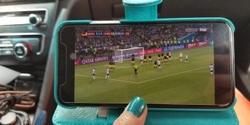 close-up-person-hand-watching-tv-mobile-phone-car (1)
