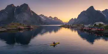 Scenic view of Lofoten Islands, Norway, with fjords and fishing villages under a bright sky.